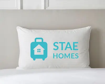 a pillow with a suitcase and a tag with a house at The Cornish Peak Beautiful Apartment In Grade 2 Listed Building In Cornwall By STAE-Homes in Camelford