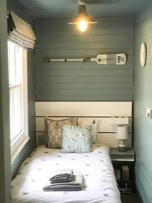 a bed in a room with green striped walls at The Cornish Peak Beautiful Apartment In Grade 2 Listed Building In Cornwall By STAE-Homes in Camelford