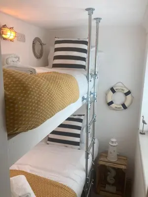 two bunk beds in a small room with at ABOVE PORTHMINSTER BEACH - 