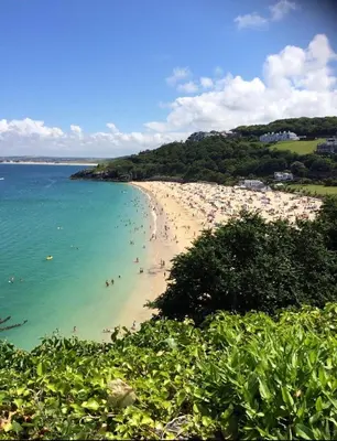 a beach with a bunch of people in the water at ABOVE PORTHMINSTER BEACH - 
