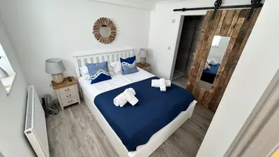 a bedroom with a bed with towels on it at ABOVE PORTHMINSTER BEACH - 