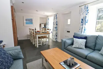 a living room with a couch and a table at Idyllic Cottage near Padstow in Little Petherick