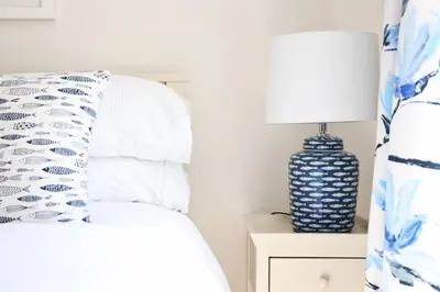 a bedroom with a bed and a lamp on a nightstand at Idyllic Cottage near Padstow in Little Petherick