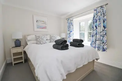 a bedroom with a bed with towels on it at Idyllic Cottage near Padstow in Little Petherick