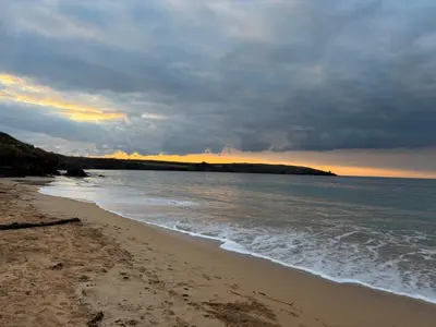 a beach with a cloudy sky and the ocean at Idyllic Cottage near Padstow in Little Petherick