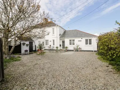 a white house with a gravel driveway at Badgers Way in Tintagel