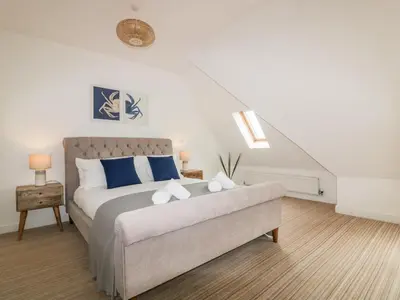 a bedroom with a bed with blue and white pillows at Crabs and Lobsters in Newquay