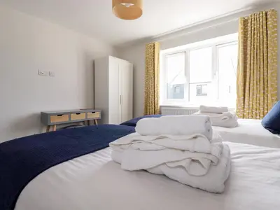 a bedroom with two beds with white towels on them at Chi Gwynn in Newquay