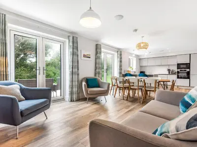 a living room with a couch and chairs and a table at Chi Gwynn in Newquay