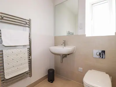 a bathroom with a toilet and a sink and a mirror at Chi Gwynn in Newquay