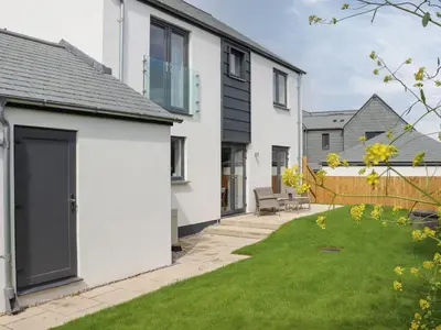a white house with a yard with green grass at Chi Gwynn in Newquay