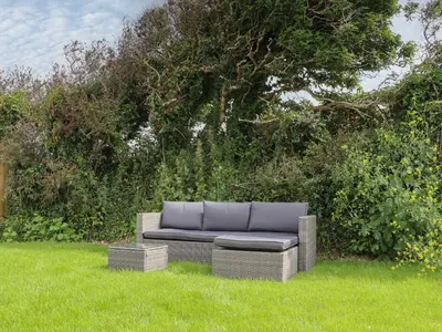 a couch sitting in the grass in a field at Chi Gwynn in Newquay