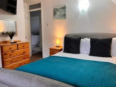a bedroom with a bed and a dresser and a television at 44 Trevithick view in Saint Erth