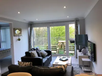 a living room with a couch and a television at 2 Bed Villa Sleeps 4 - Wifi Garden Sea Views in Looe