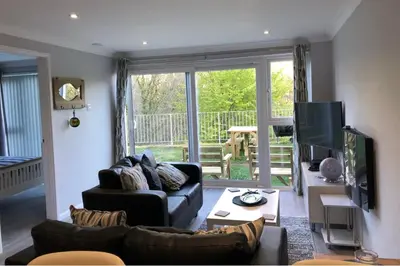 a living room with a couch and a television at 2 Bed Villa Sleeps 4 - Wifi Garden Sea Views in Looe
