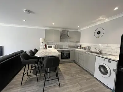 a kitchen with a table and chairs and a laundry room at 2 Bed Villa Sleeps 4 - Wifi Garden Sea Views in Looe