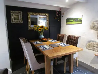 a dining room with a wooden table and chairs at Trenwith Bridge Cottage in St Ives