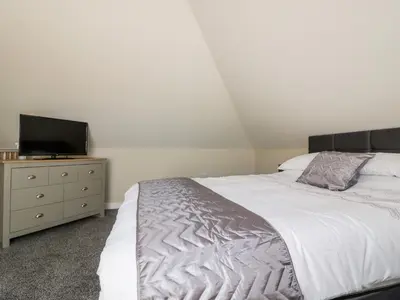 a bedroom with a bed and a tv on a dresser at The Hayloft in Bodmin