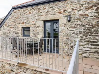 a balcony with a table and chairs on a brick building at The Hayloft in Bodmin