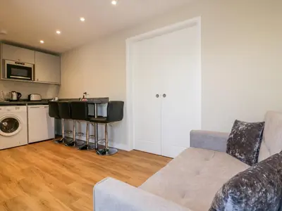 a living room with a couch and a kitchen at The Granary in Bodmin
