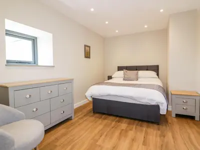 a bedroom with a bed and a dresser and a window at The Granary in Bodmin