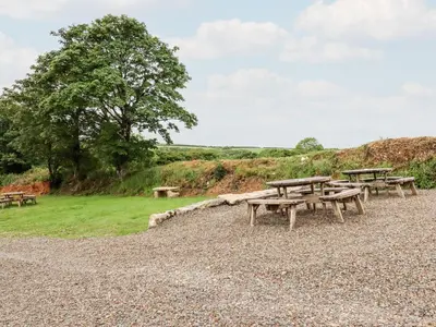 a group of picnic tables on a gravel field at The Granary in Bodmin