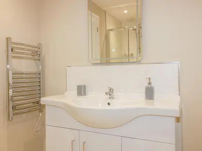 a bathroom with a white sink and a mirror at The Granary in Bodmin