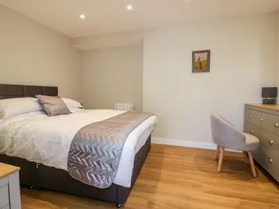 a bedroom with a bed and a desk and a chair at The Cornstore in Bodmin