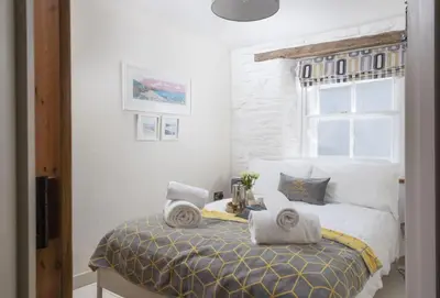 a bedroom with a bed with towels on it at Oriel Cottage in St. Agnes
