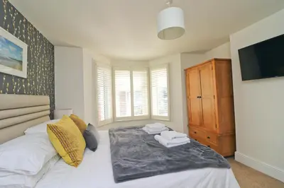 a bedroom with a bed and a tv on a wall at Padstow townhouse, close to harbour in Padstow