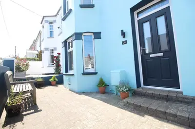 a blue house with a bench and potted plants at Padstow townhouse, close to harbour in Padstow