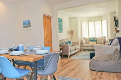 a living room with a table and blue chairs at Padstow townhouse, close to harbour in Padstow