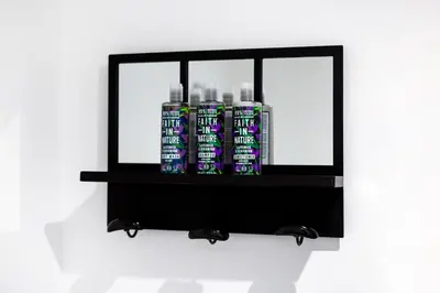 a shelf with four bottles on a wall at Park View in Falmouth