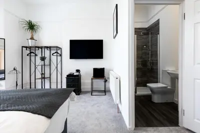 a bedroom with a bed and a bathroom with a television at Park View in Falmouth