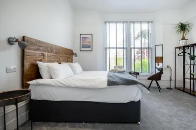 a bedroom with a large bed with a wooden headboard at Park View in Falmouth