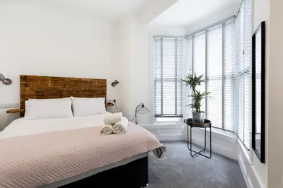 a bedroom with a large bed and windows at Park View in Falmouth