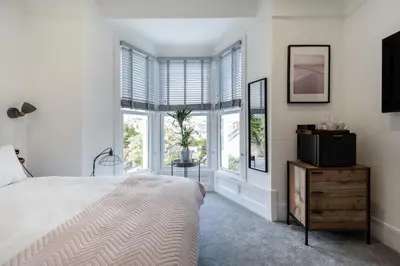 a bedroom with a bed and a tv and windows at Park View in Falmouth