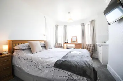 a bedroom with a large bed and a window at No 10 Treverbyn Road B & B in Padstow