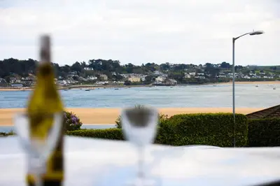 a table with a bottle of wine and a view of the beach at No 10 Treverbyn Road B & B in Padstow