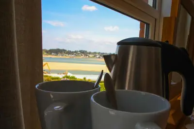 two cups on a window sill with a view of the beach at No 10 Treverbyn Road B & B in Padstow