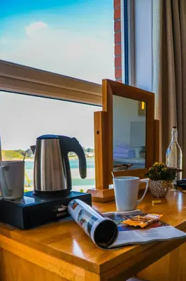 a table with a coffee maker and cups on it at No 10 Treverbyn Road B & B in Padstow