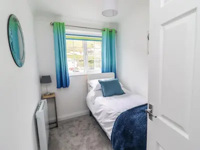 a small bedroom with a bed and a window at Beach Cottage in Redruth