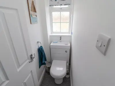 a small bathroom with a toilet and a window at Beach Cottage in Redruth