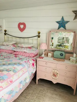 a bedroom with a bed and a mirror and a dresser at Shabby Shack near Charlestown & The Eden Project in St Austell
