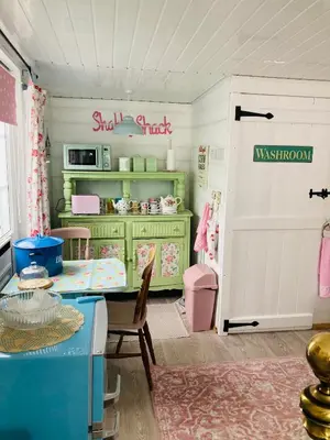 a room with a table and a kitchen with a door at Shabby Shack near Charlestown & The Eden Project in St Austell