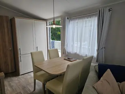 a dining room table and chairs in a living room at Mawgan Pads Trevella Crantock in Crantock