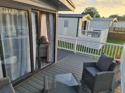 a screened porch with chairs and a glass table at Mawgan Pads Trevella Crantock in Crantock