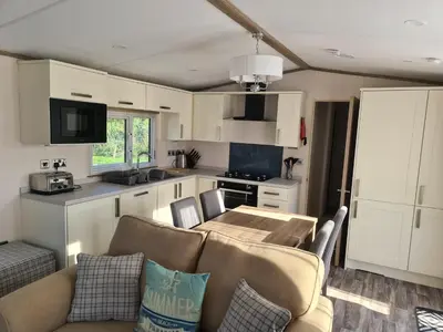 a living room with a couch and a table in a kitchen at Mawgan Pads Trevella Crantock in Crantock