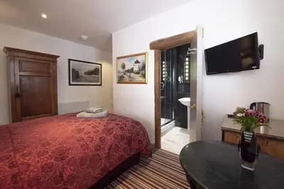 a hotel room with a bed and a television at Cornerways Guest House in St Ives