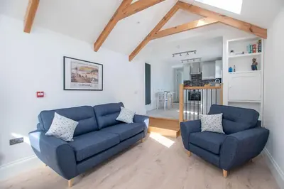 a living room with a blue couch and two chairs at Marcella's Retreat in St Ives